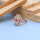 "Elegant Rose Gold Floral Ring with Pink Gemstone & White Accents"